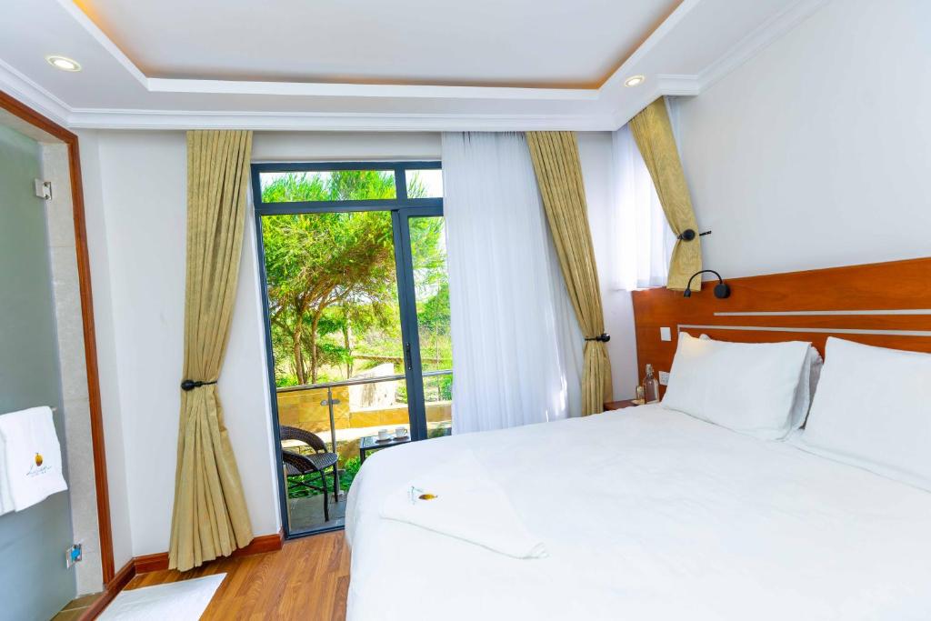 a bedroom with a bed and a large window at Lusoi Gardens Naromoru in Nyeri