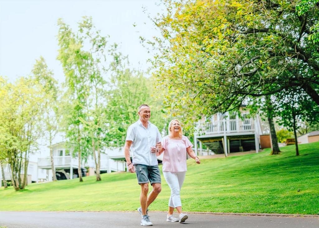 a man and a woman walking down a street at Heather View Holiday Park in Stanhope