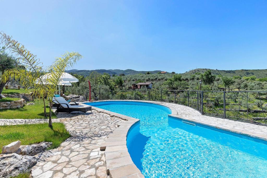 a swimming pool in a yard with a bench next to it at Villa Luisana con Piscina e Vista in Sonnino