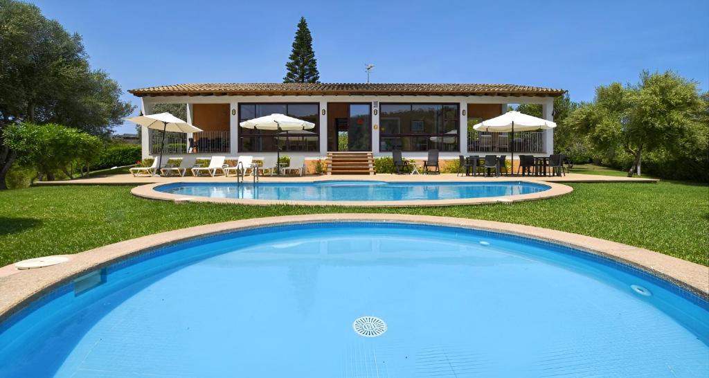 a large swimming pool in front of a house at Sa Font den Ros Mallorca in Son Servera