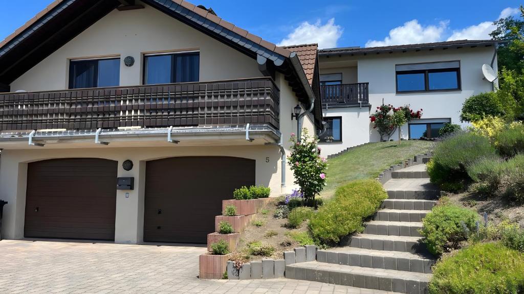 a house with two garage doors and stairs at Maarträumchen in Gillenfeld in Gillenfeld