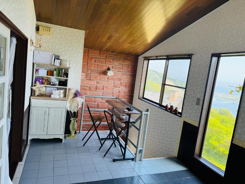 a room with a kitchen with a table and windows at Amoria 2 in Miyazaki