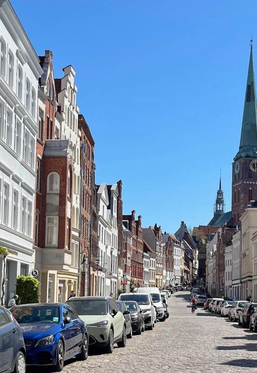 a row of cars parked on a street with buildings at Historisches Ganghaus "Bluebelle" in Lübeck