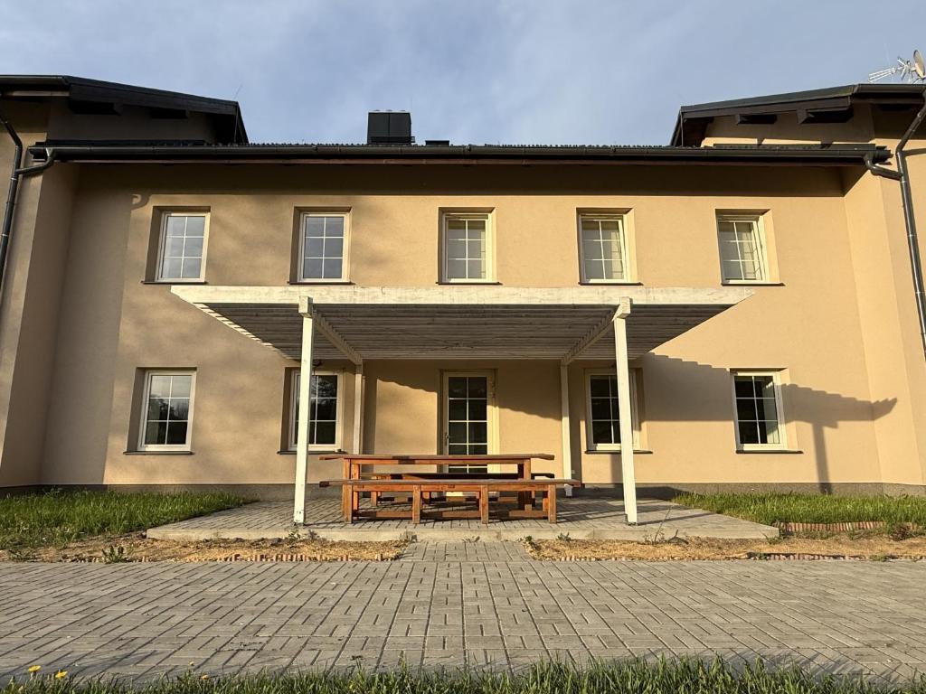 a building with a wooden bench in front of it at Apartmány Papírna in Ostrov