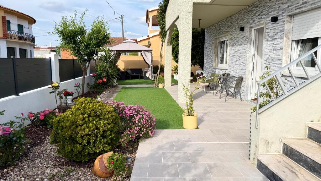 a garden with flowers and plants on a house at Refúgio Ribatejano in Alpiarça
