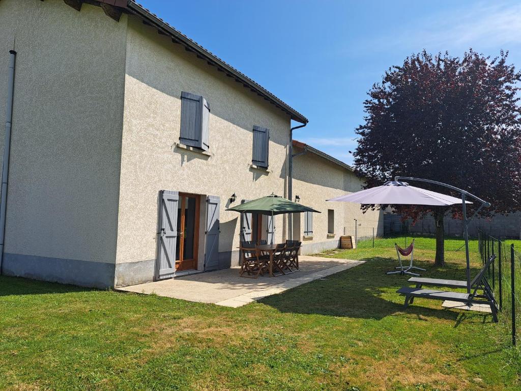 a house with a picnic table and an umbrella at Maison Céline - Jardin clos et Parking Privé Gratuit in Crevant-Laveine