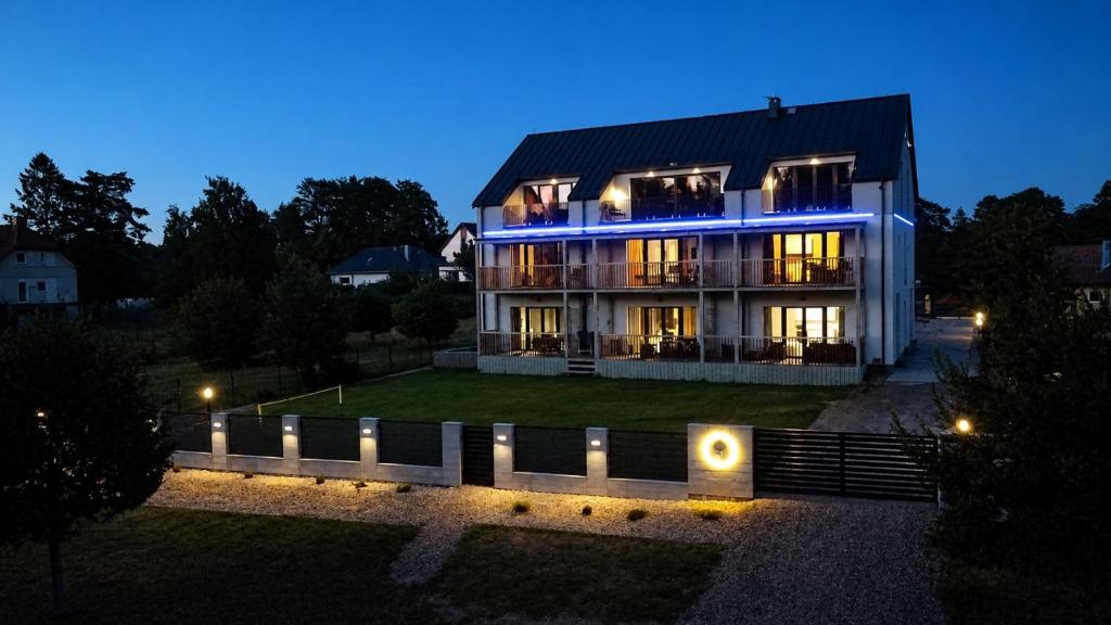 a large house at night with lights on it at Flauta Apartamenty in Augustów