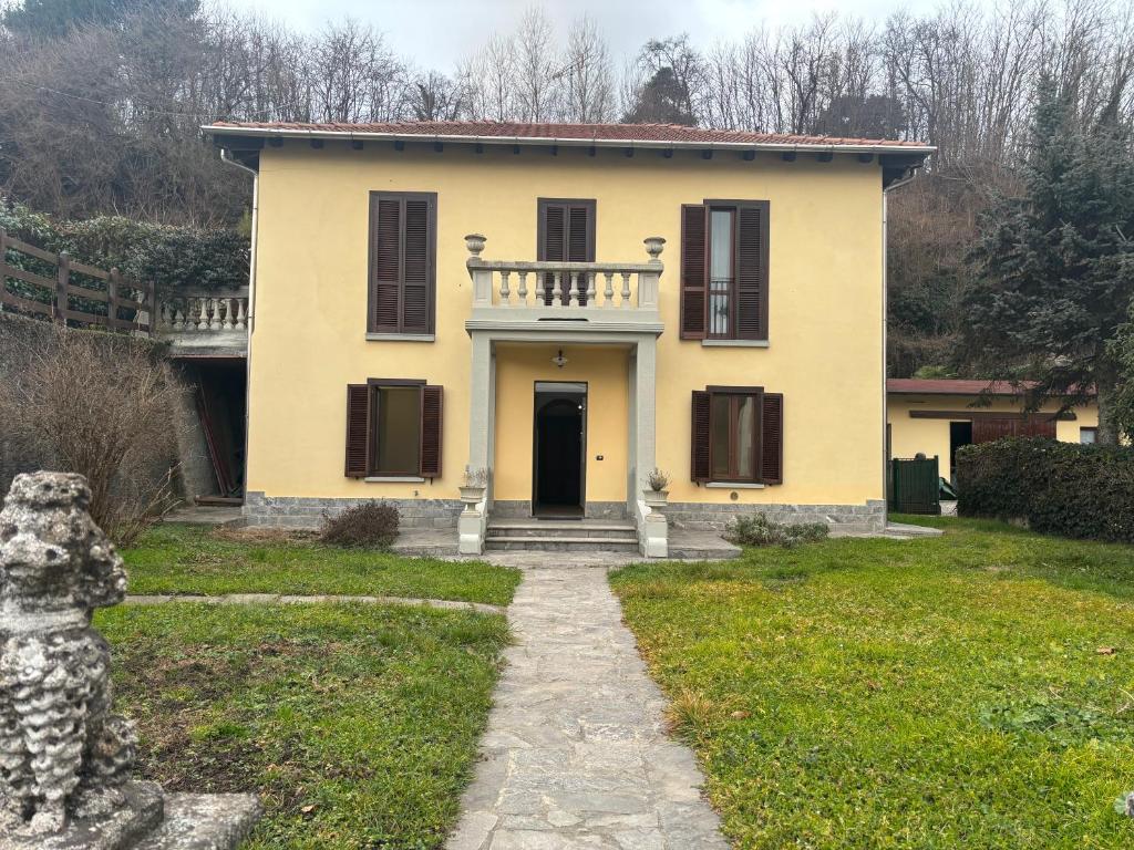 a yellow house with a porch and a door at B&B Luna in Sesto Calende