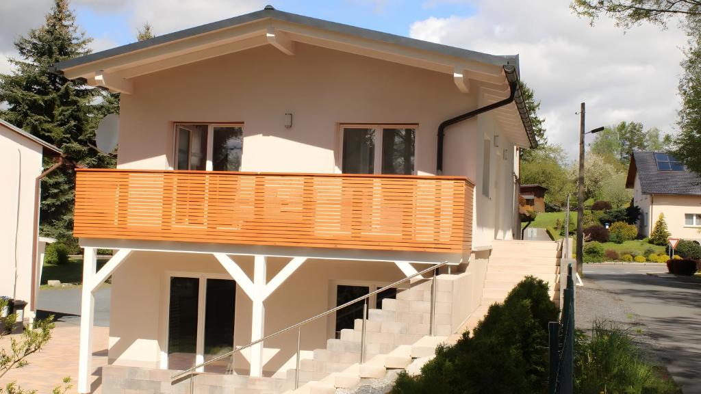 a house with a deck on the side of it at Ferienhaus am Mühlteich in Neuhaus-Schierschnitz