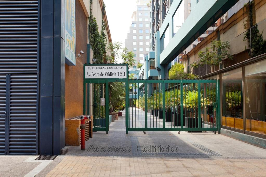 a green and white street sign next to a building at Apart Hotel Cambiaso in Santiago