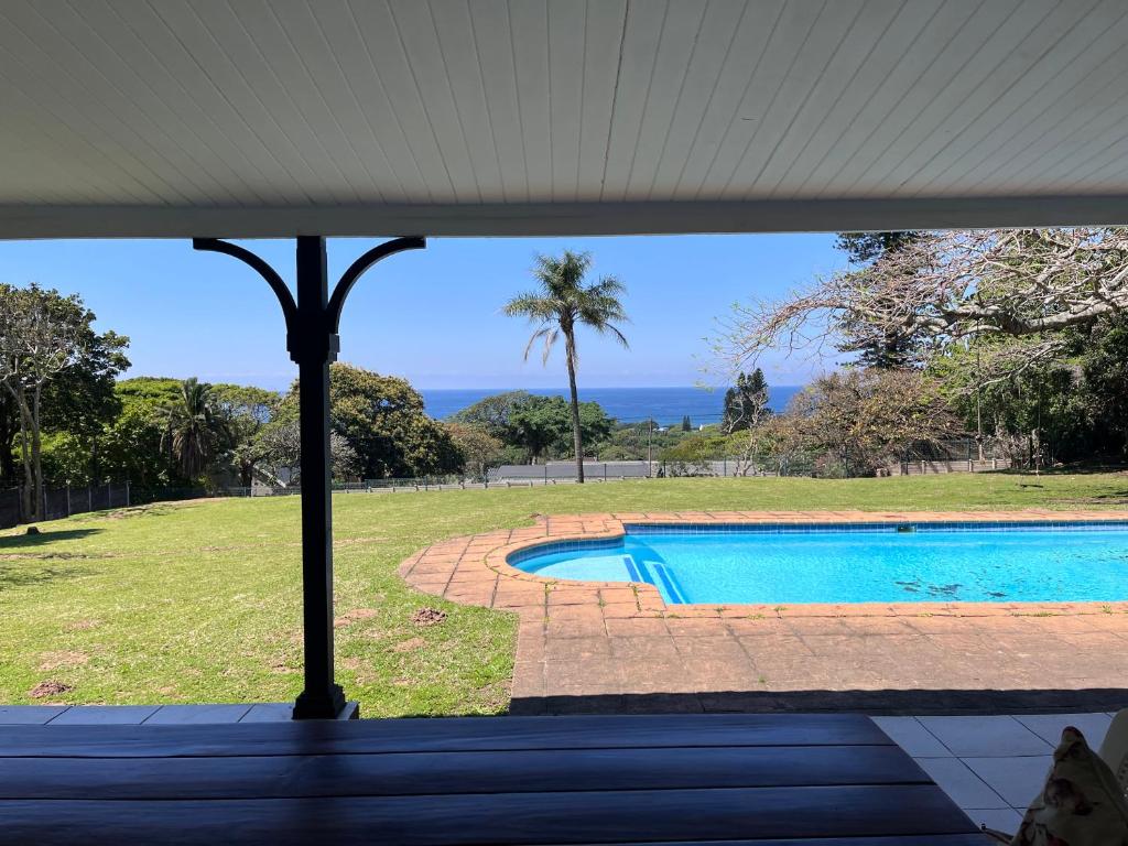 a view of a swimming pool from the porch of a house at Eight Umdoni North in Pennington