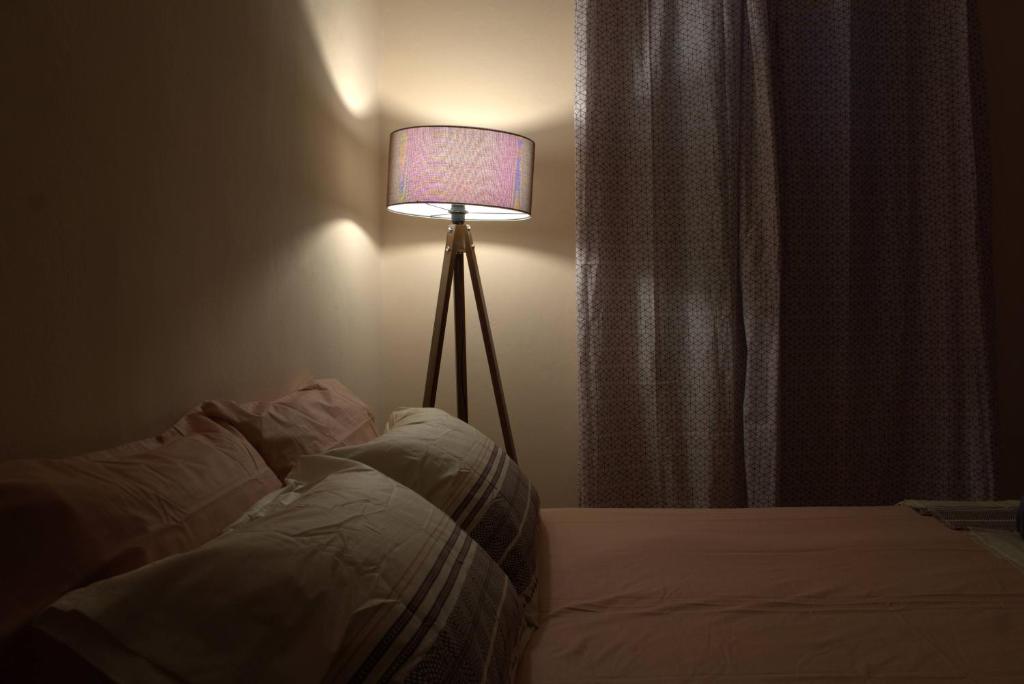a bedroom with a bed with a lamp next to a window at Hidden gem agora flat Checkpoint-Mytilene in Mytilene