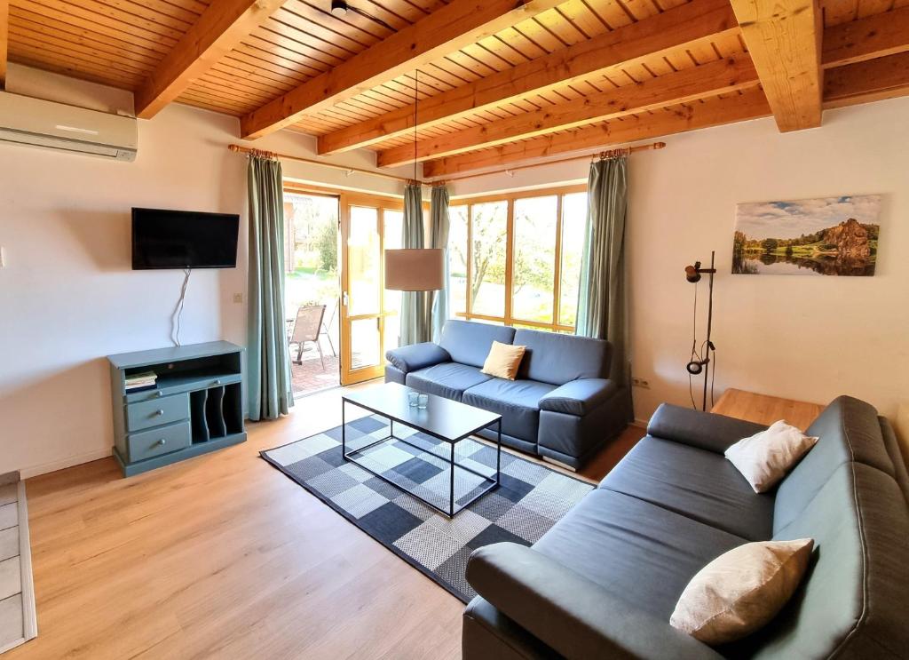 a living room with a couch and a table at Haus 16 im Natur Ferienpark, Natur, Abenteuer und Entspannung für unvergessliche Urlaubstage in Nieheim
