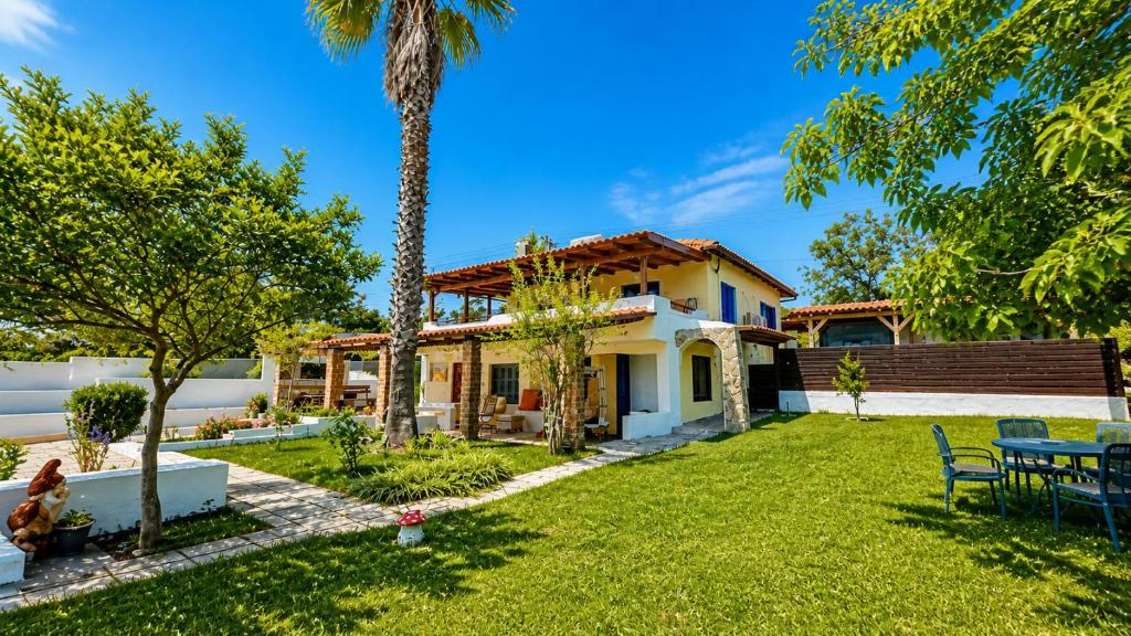 a house with a yard with a palm tree at Casa de Palma in Asprovalta