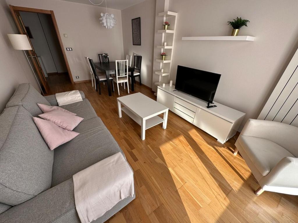 a living room with a couch and a tv at Playa América 2C by YBH in Nigrán