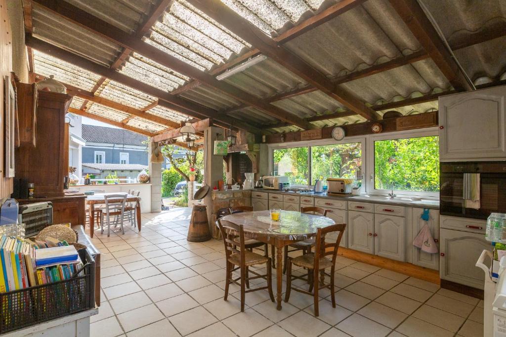 a kitchen with a table and some chairs in it at La Charrette in Dunières-sur-Eyrieux