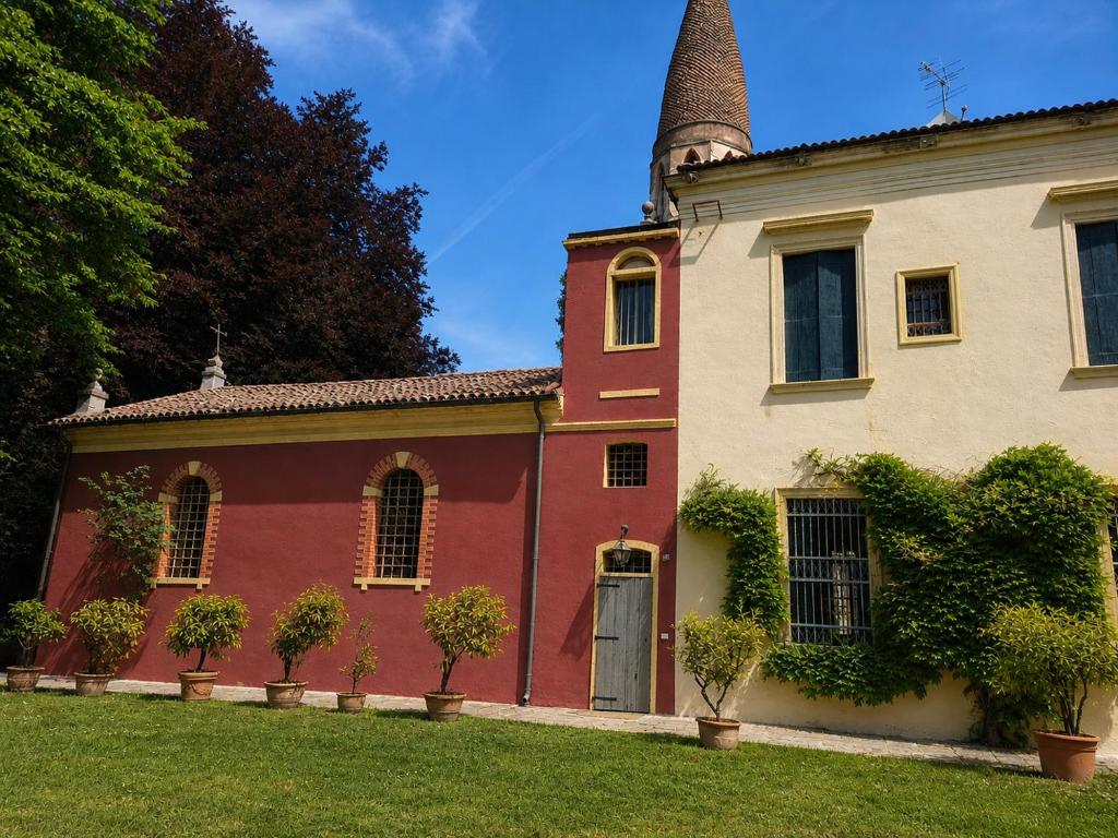 an old house with a turret and a yard at Wisteria Lodge by Veneto Villa in Albignasego