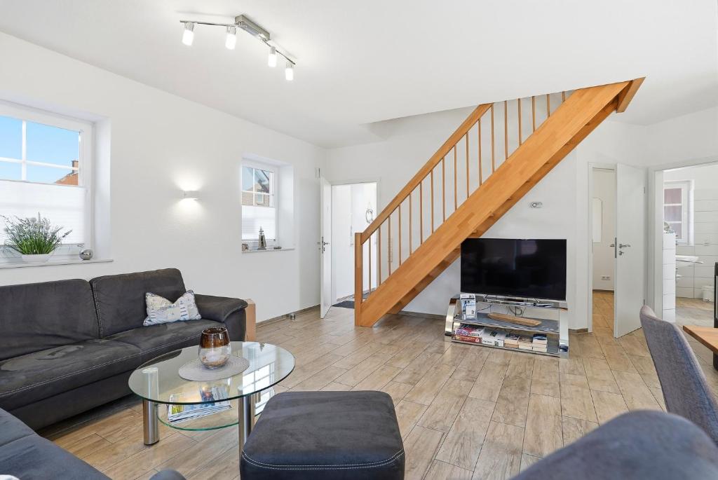 a living room with a couch and a tv at Nordseeperle in Greetsiel