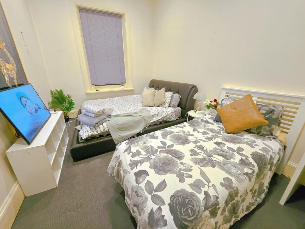 a bedroom with two beds and a television in it at Eden - Franklin 6 in Adelaide