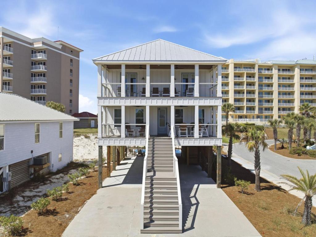 a house on the beach with condos in the background at The Perch in Gulf Shores