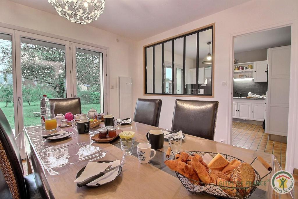 a dining room with a table with a basket of bread at Maison d'hôtes de kervor in Plouézec