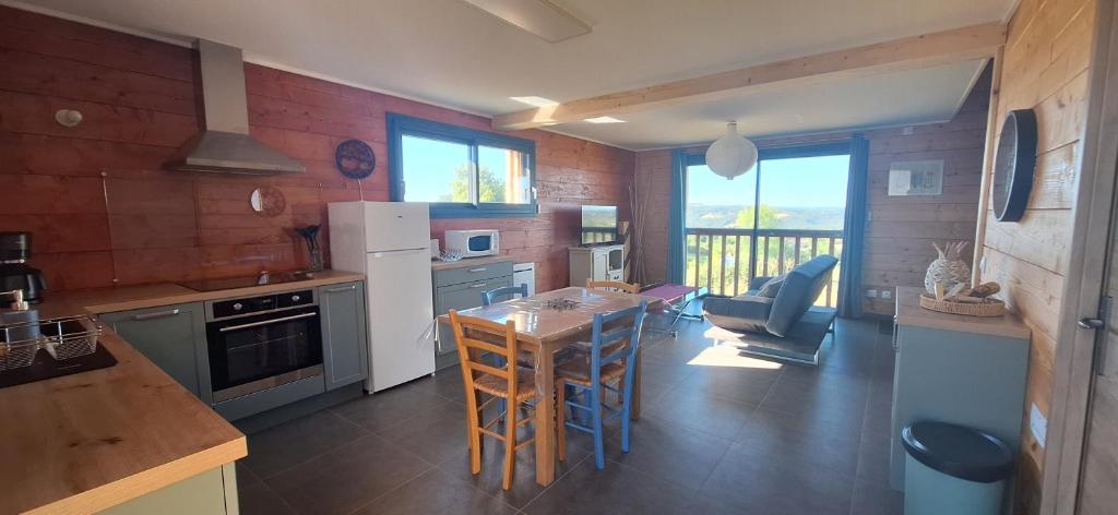 a kitchen with a table and chairs in a room at La Maison En Bois in Figeac