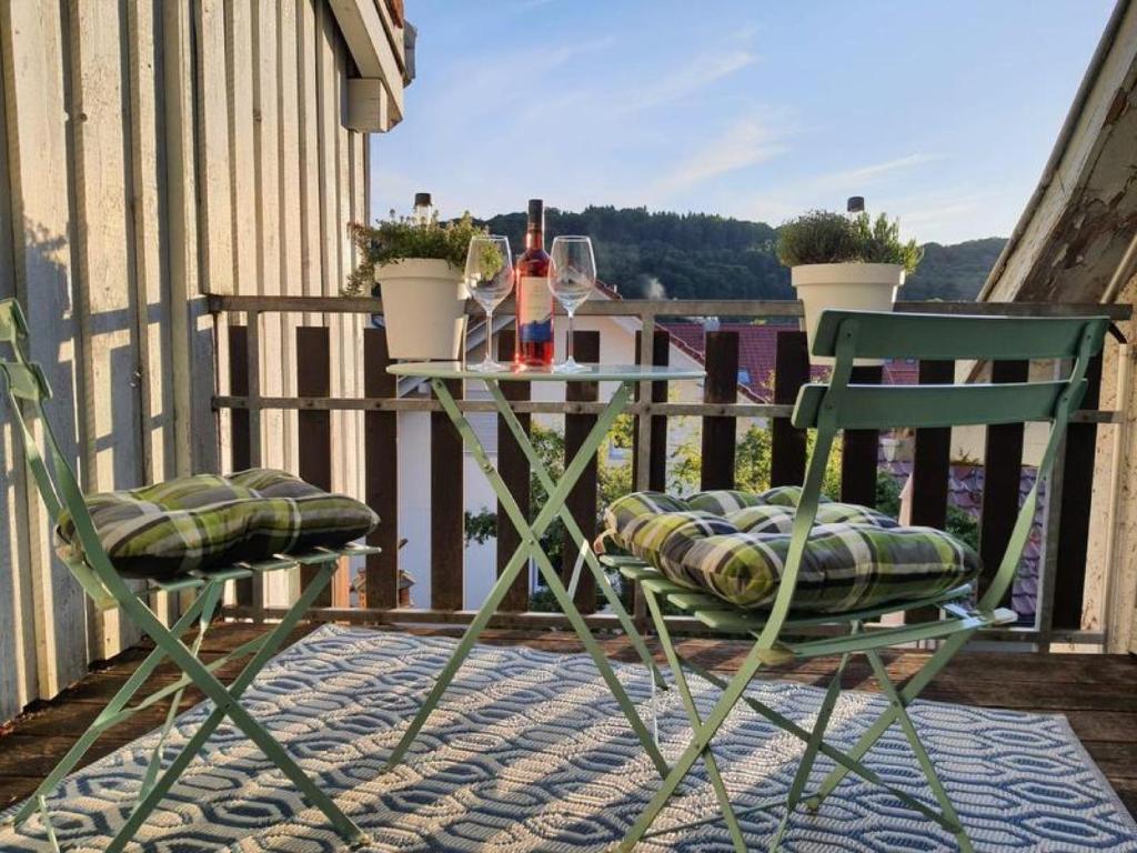 Zwei Stühle und ein Tisch auf einem Balkon mit einer Flasche Wein in der Unterkunft Brendle in Sankt Johann