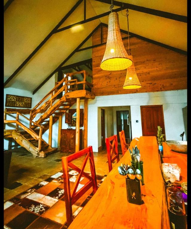 a dining room with a wooden table and a light fixture at TheCabinsNanyuki in Nanyuki