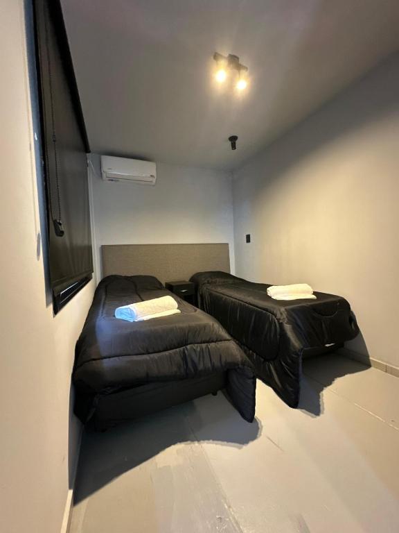 two beds in a small room with avertisementvertisementvertisementvertisementvertisementvertisementvertisementvertisement at BoxPoint MotoResort in Córdoba