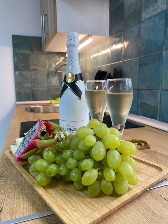 a bottle of wine and a bunch of grapes on a cutting board at BEACH Arguineguin FIRST LINE CHG FAMILY HOTEL in Arguineguín