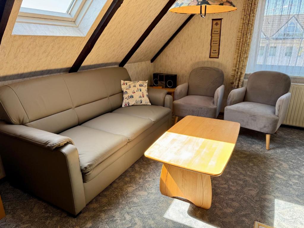 a living room with a couch and two chairs and a table at Nordsee 409 in Wangerooge