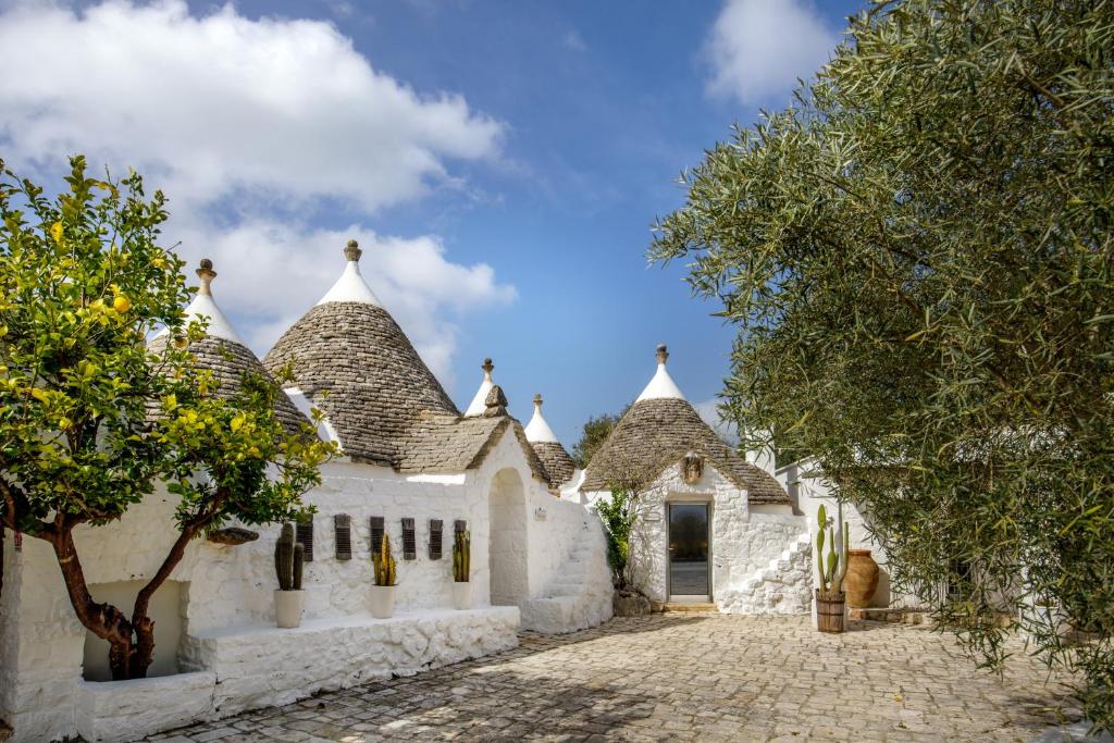 a white house with turrets and a driveway at Puntebianche Resort in Ceglie Messapica
