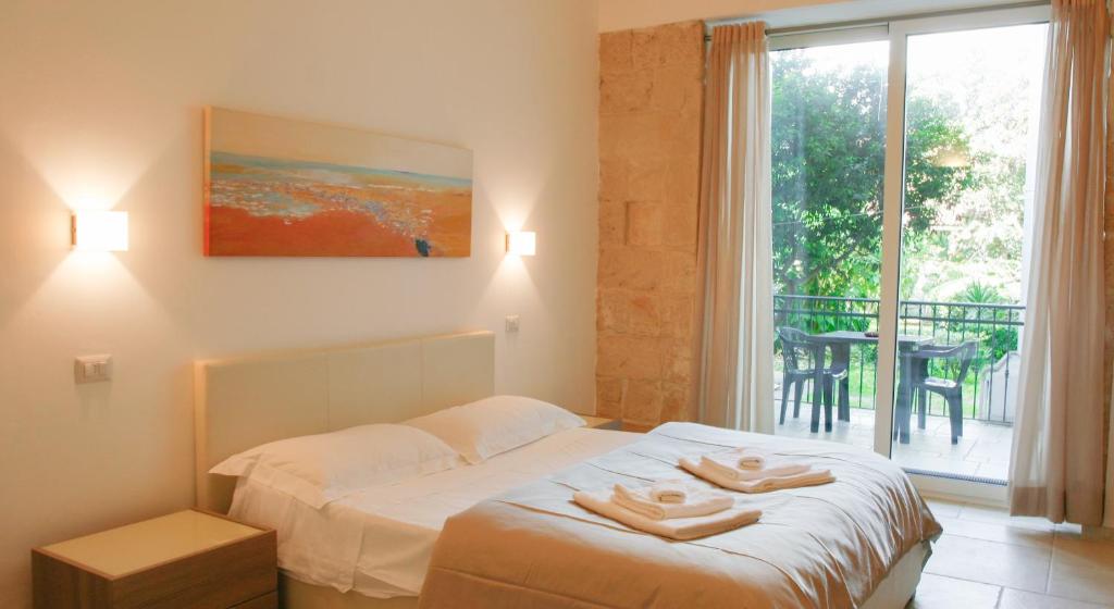a bedroom with a bed with two towels on it at La Bella Lecce Apartment in Lecce