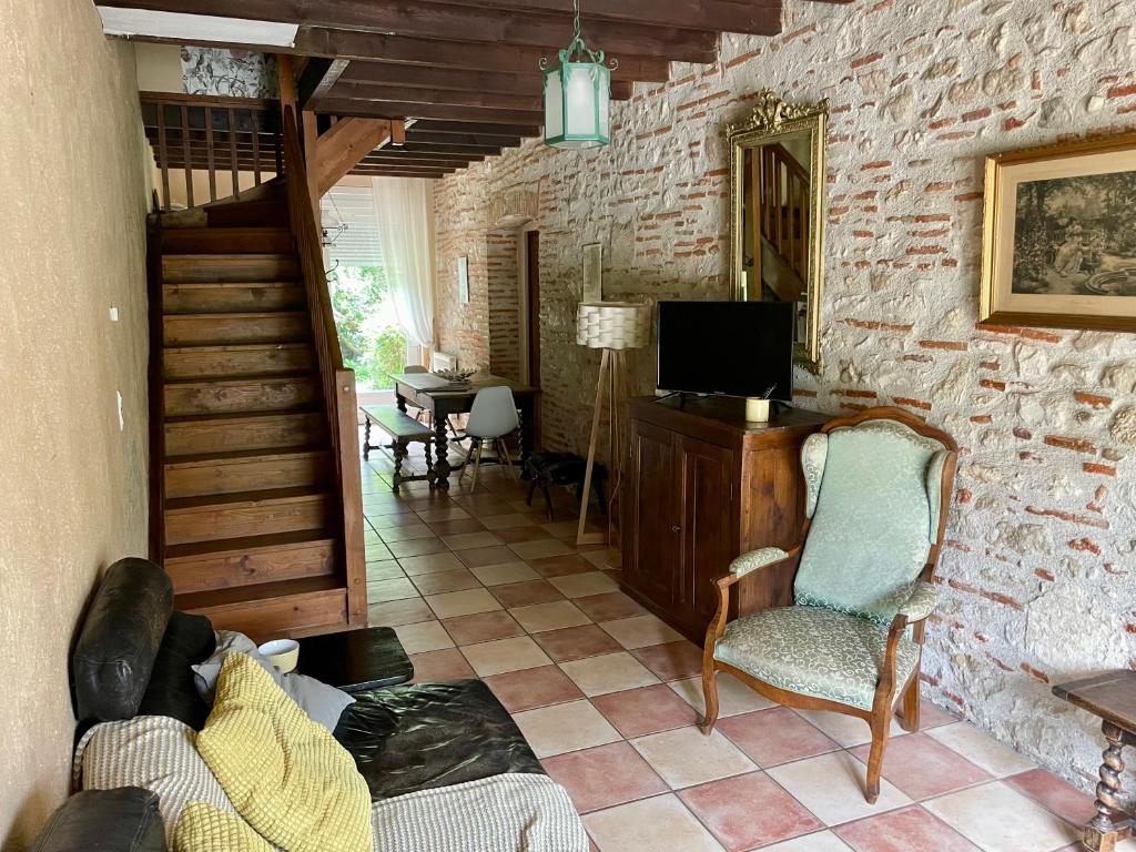 a living room with a couch and a tv at Manoir La Bordeneuve in Villeneuve-sur-Lot