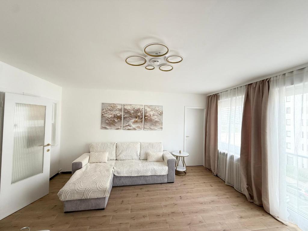 a white living room with a couch and a ceiling at Marine Résidence in De Panne