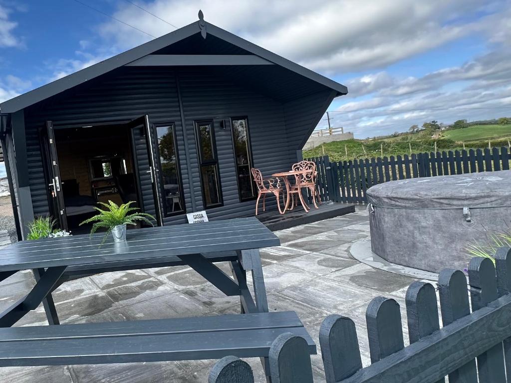 a black shack with a picnic table in front of it at CASSA Sophia in Ballygowan