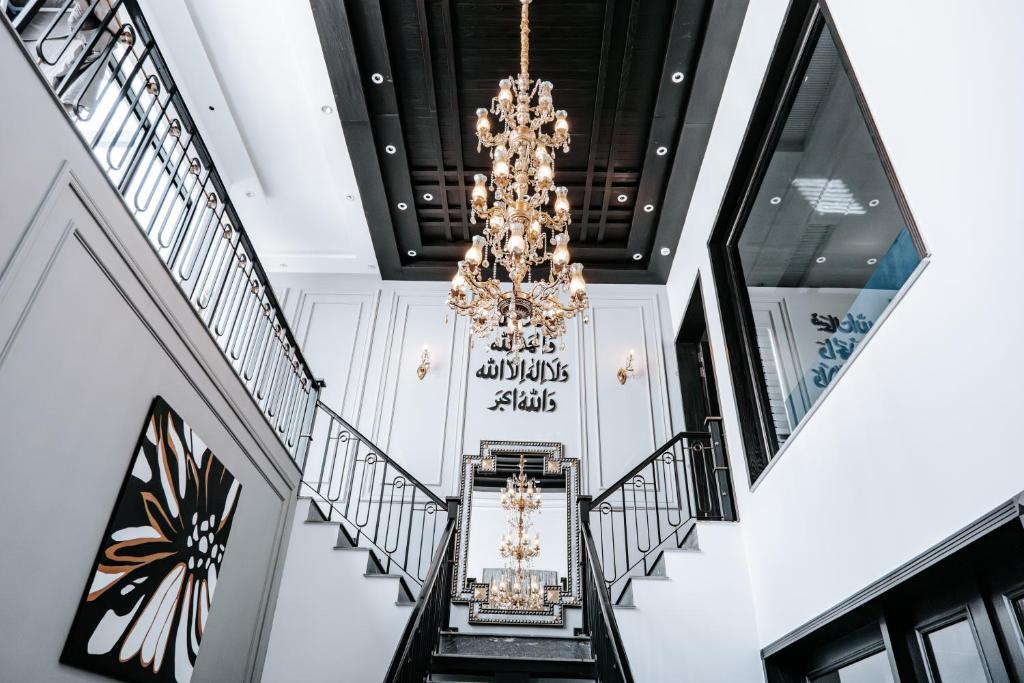 a staircase with a chandelier in a building at Summer Villa in Lahore