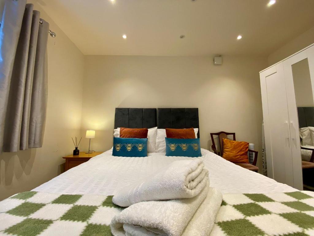 a bedroom with a bed with towels on it at Modern 2 bed ground floor flat in Watford
