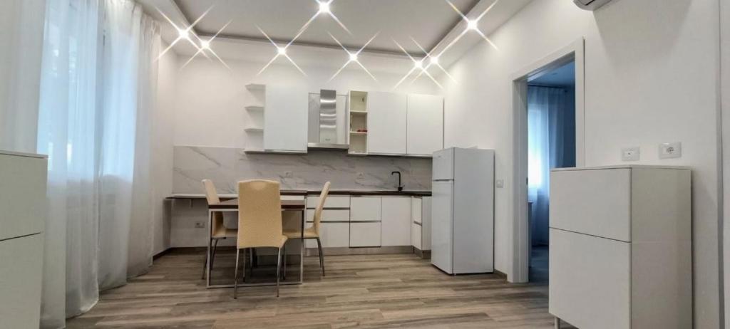 a kitchen with white cabinets and a table and chairs at Chez Romeo in Ravenna