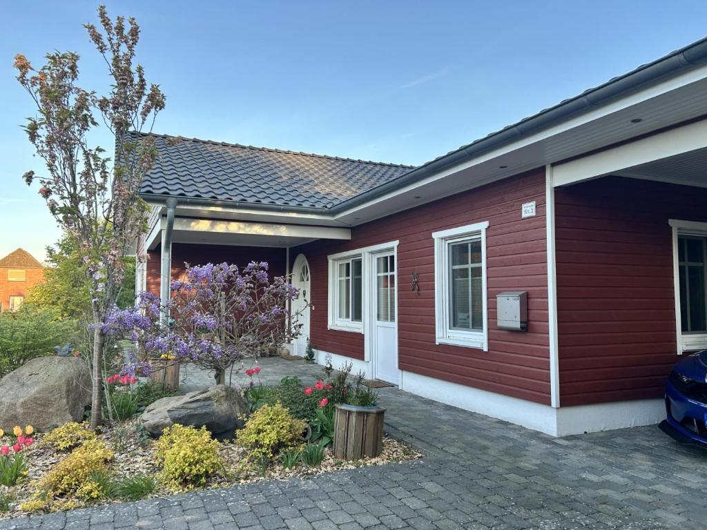 a red house with flowers in front of it at Kleine Weite-Das Schwedenhus in Landesbergen