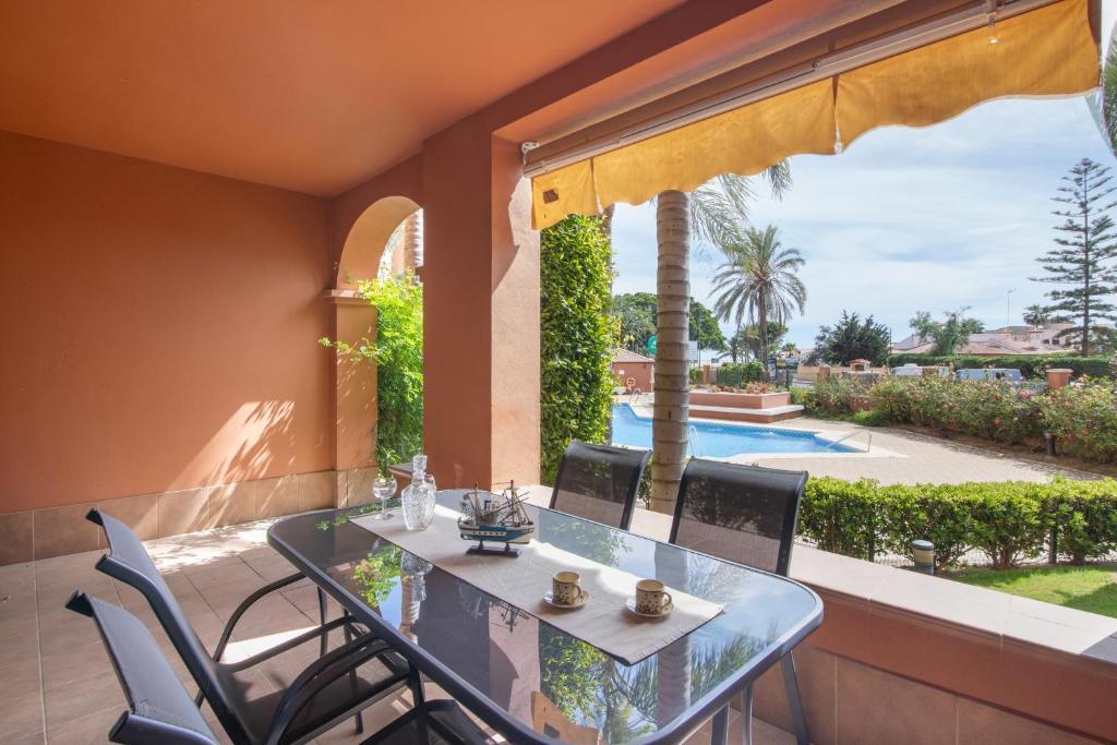 a balcony with a table and chairs and a pool at Inmacanela playa in Isla Canela