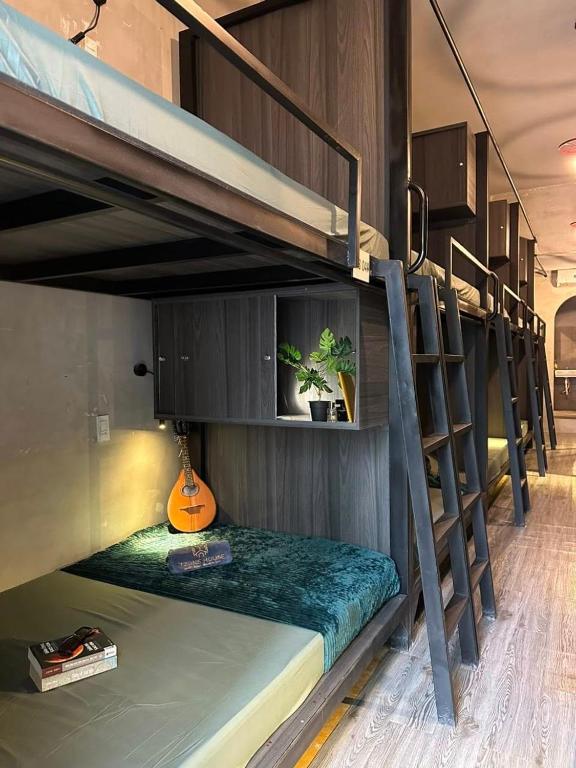 a room with two bunk beds with a guitar at Tzone's Hostel - Quiet Place in Ho Chi Minh City