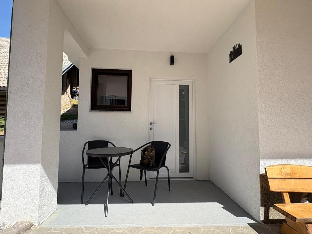 a patio with a table and chairs and a mirror at Cosy Studio CatHouse in Radovljica
