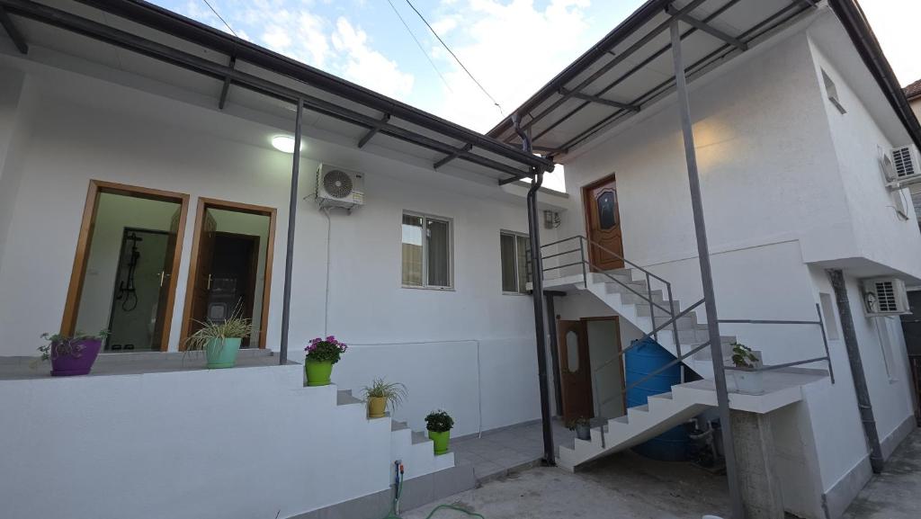 a white house with a staircase in front of it at Aer Rooms Peshkopi in Peshkopi