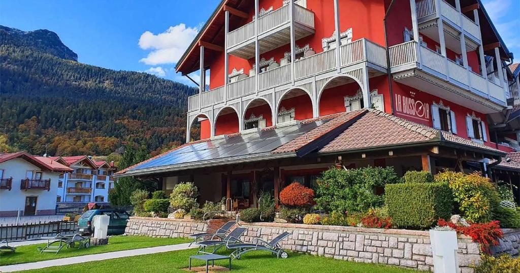 a large red building with benches in front of it at Hotel La Bussola in Andalo