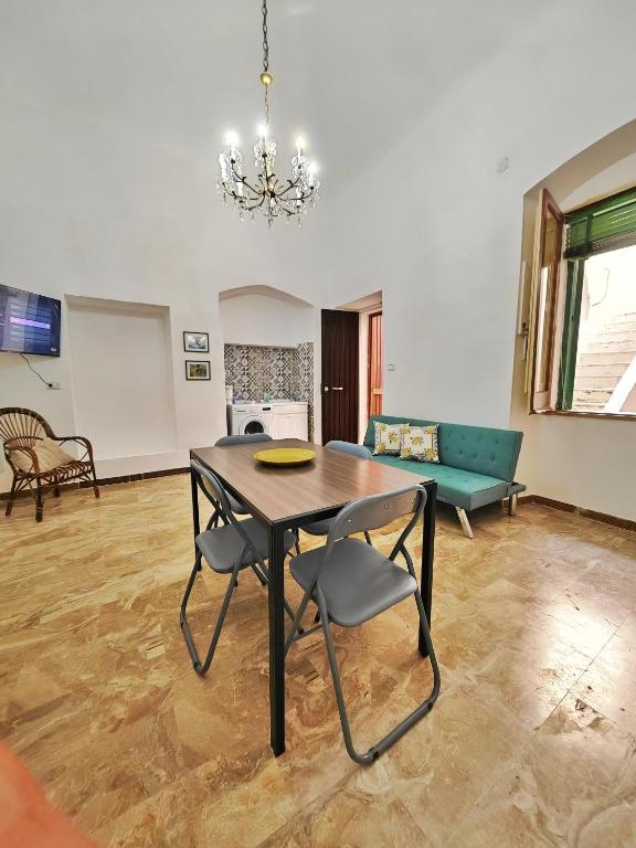 a dining room with a table and a couch at Zio Achille in Gallipoli