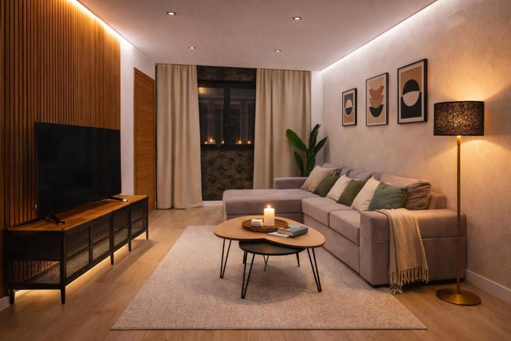 a living room with a couch and a television at Ohana Boutique Málaga Centro in Málaga