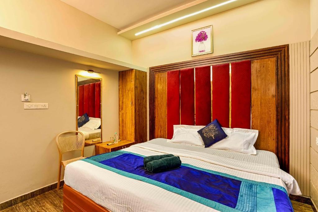 a bedroom with a large bed and a mirror at RAGAM RESORT in Alleppey