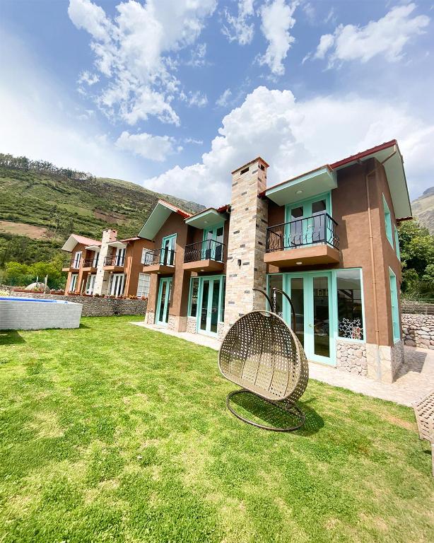 a large house with a chair in the yard at Auka Boutique in Urubamba
