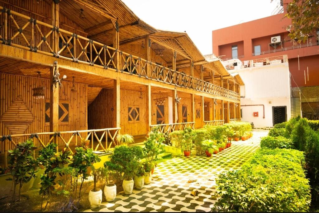 a large building with potted plants in a courtyard at Hotel First Impression in Rāmnagar